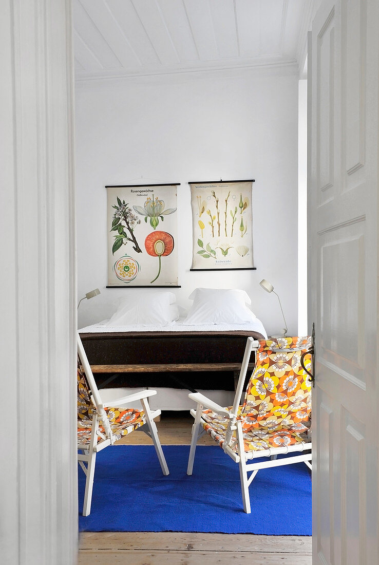 Colourful chairs and double bed in bedroom