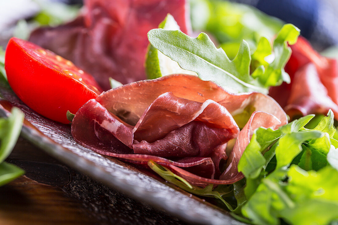 Salad bresaola arugula baby spinach tomatoes lime and cheese parmesan