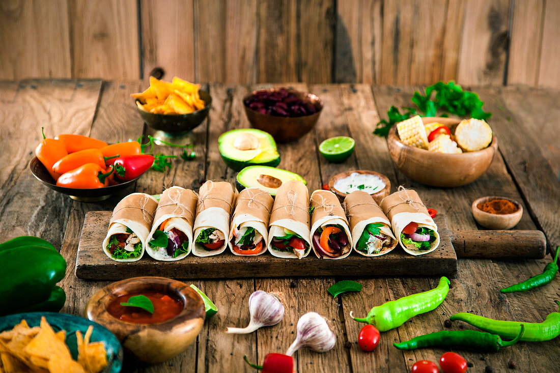 Tortilla wraps with various fillings surrounded by ingredients