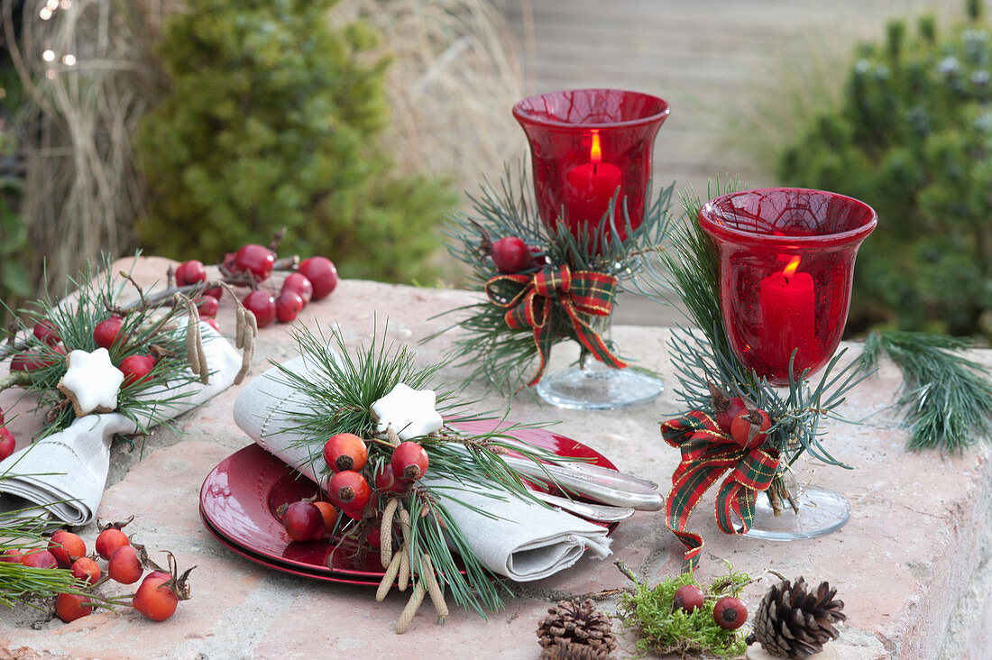 Weihnachtliche Tischdeko mit Kiefer, Hagebutten und Zieräpfeln