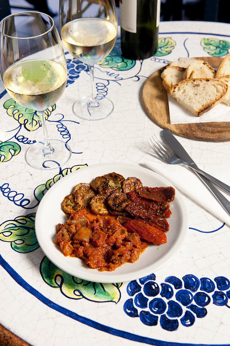 Antipasti mit Brot und Wein auf Tisch in Weinbar (Rom, Italien)