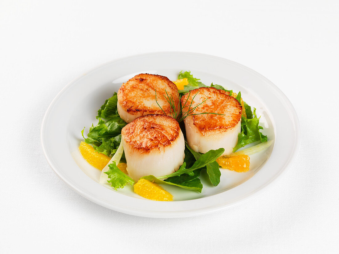 Fried scallops with salad and oranges
