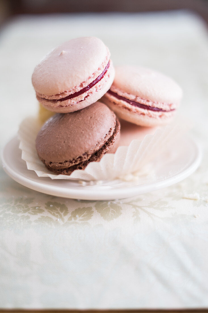 Various French macarons in a paper cup on a small plate