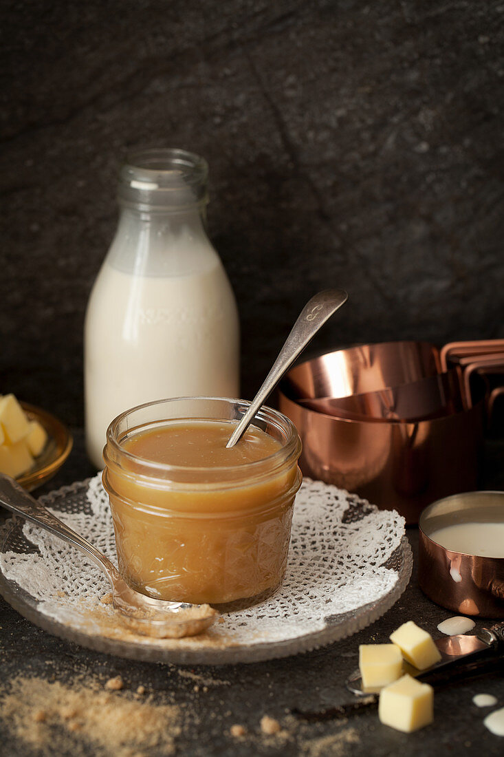 Homemade butterscotch sauce surrounded by its ingredients