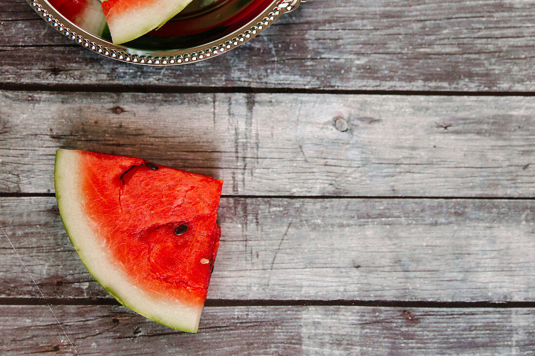 A watermelon slice on a wooden background