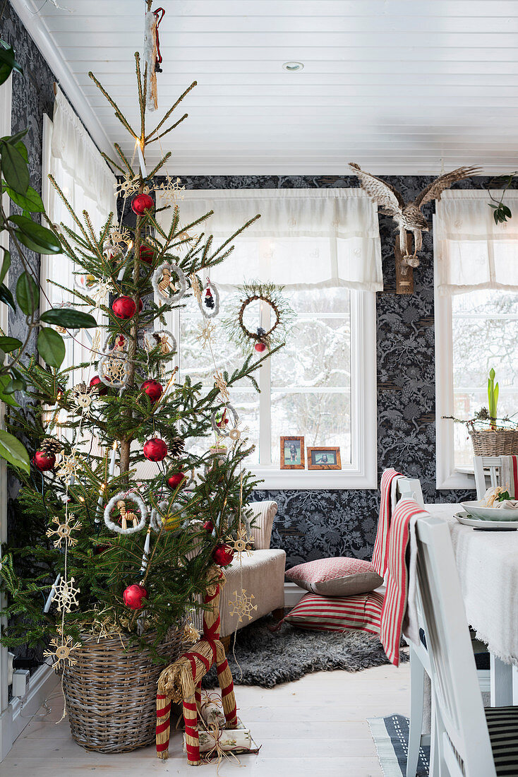 Weihnachtsbaum vor schwarz gemusterter Tapete im Essbereich