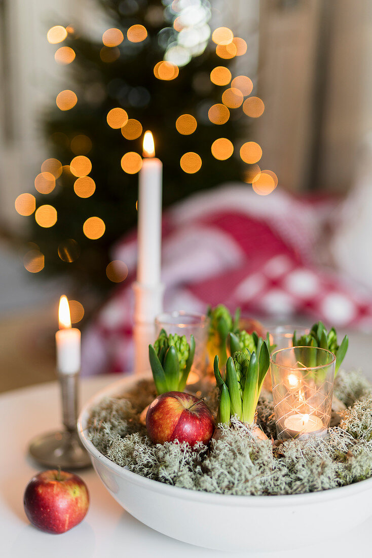 Hyacinths in bowl with apples and tealight