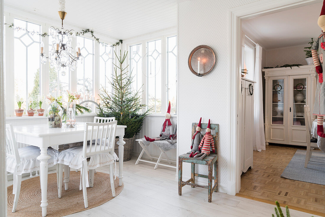 White table and chairs in festively decorated conservatory