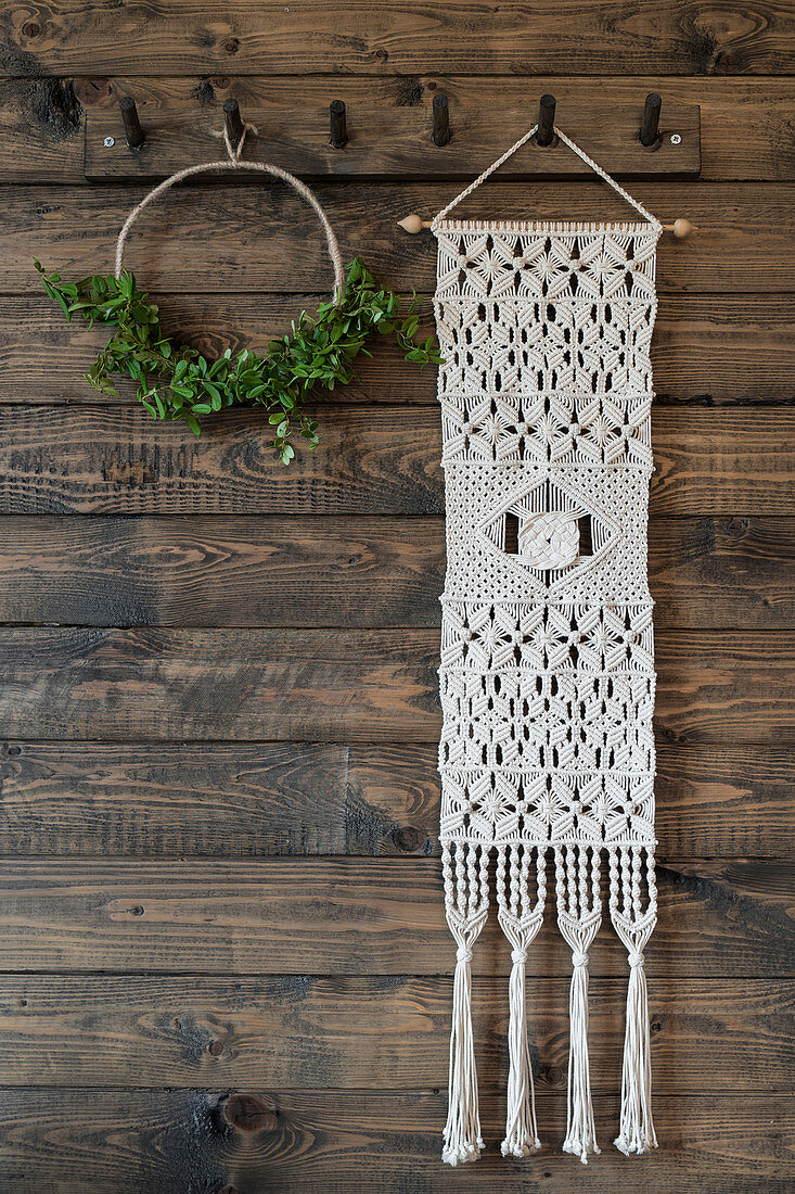 Macrame wall hanging and minimalist wreath on board wall