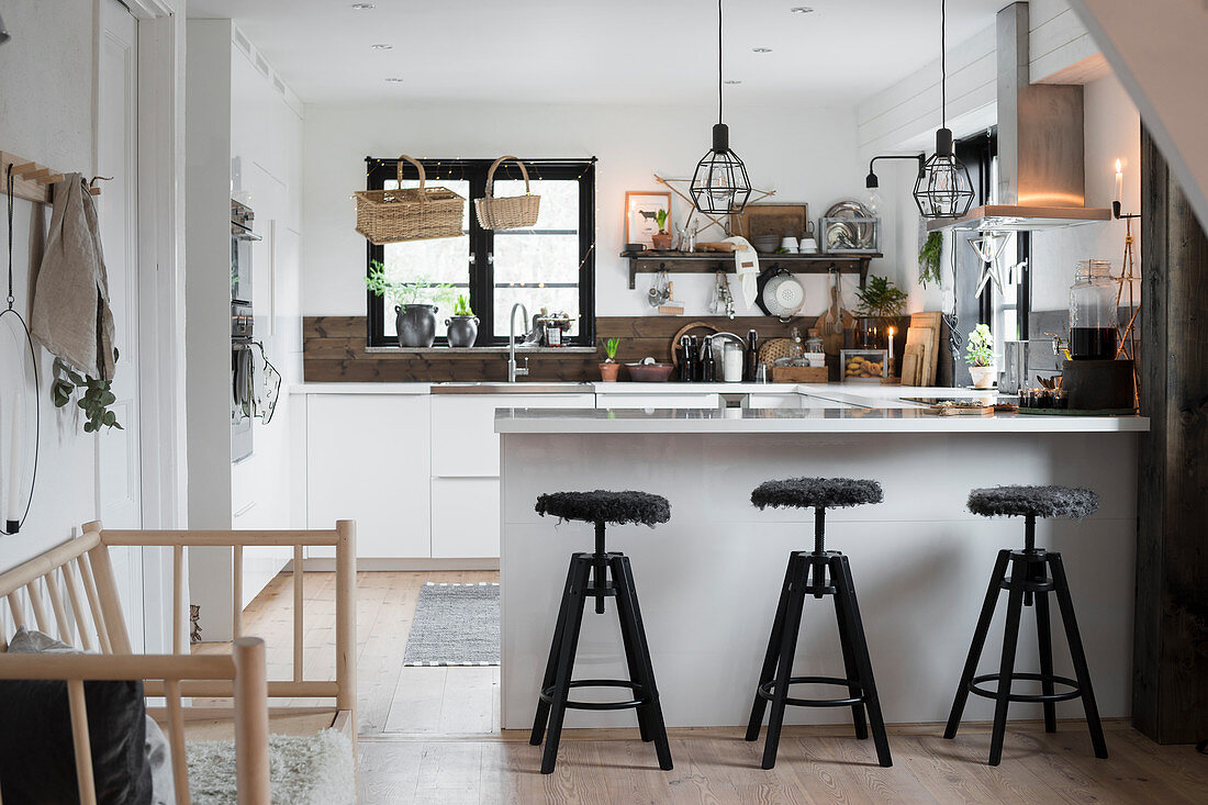 Barstools at counter in industrial-style kitchen