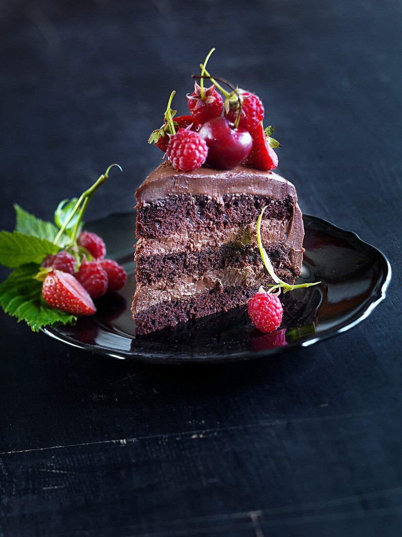 Ein Stück Schokoladenmoussetorte garniert mit frischen Beeren