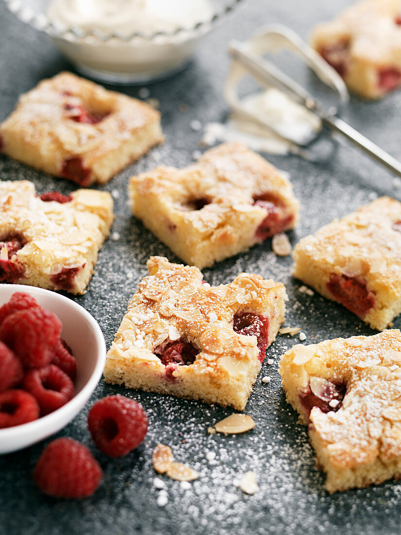 Sheet cake with almonds and raspberries, sliced