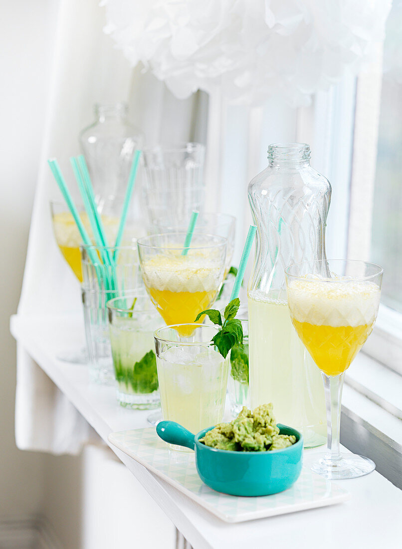 Limonade in Flaschen und Gläsern dazu Guacamole für die Sommerparty