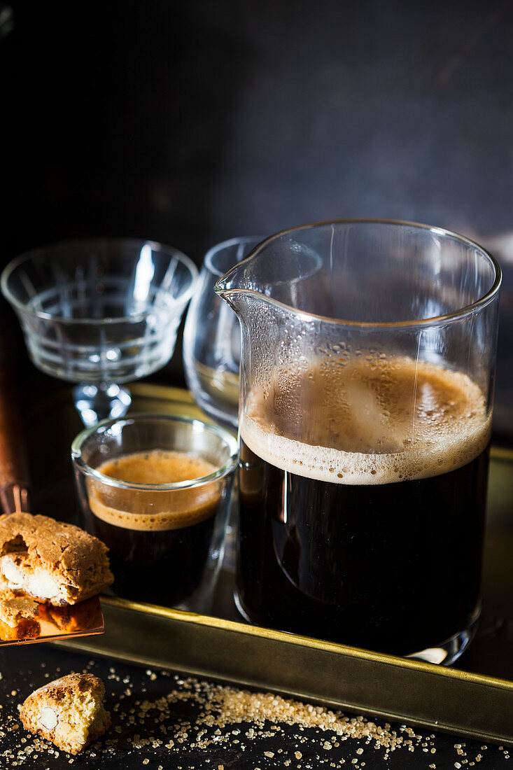 Kaffee serviert in Krug und Gläsern auf Tablett dazu Cantuccini