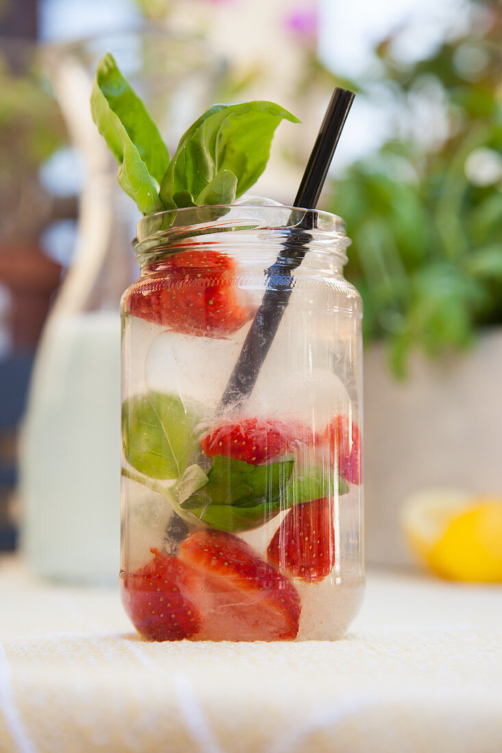 Lemonade with strawberries and basil outdoors