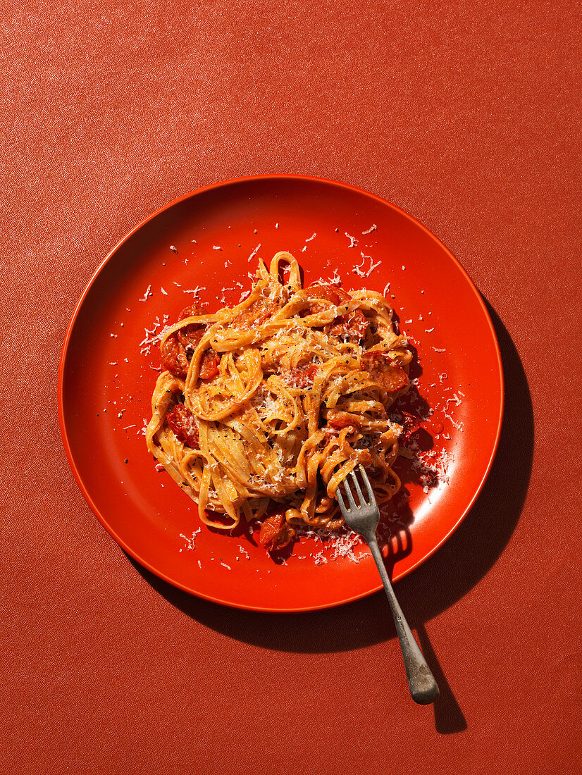 Pasta with tomato on red plate