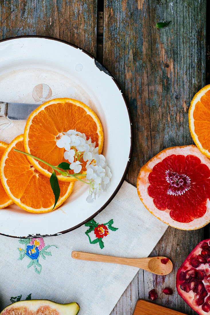 Orangenscheiben auf Teller, Grapefruit und Granatapfel