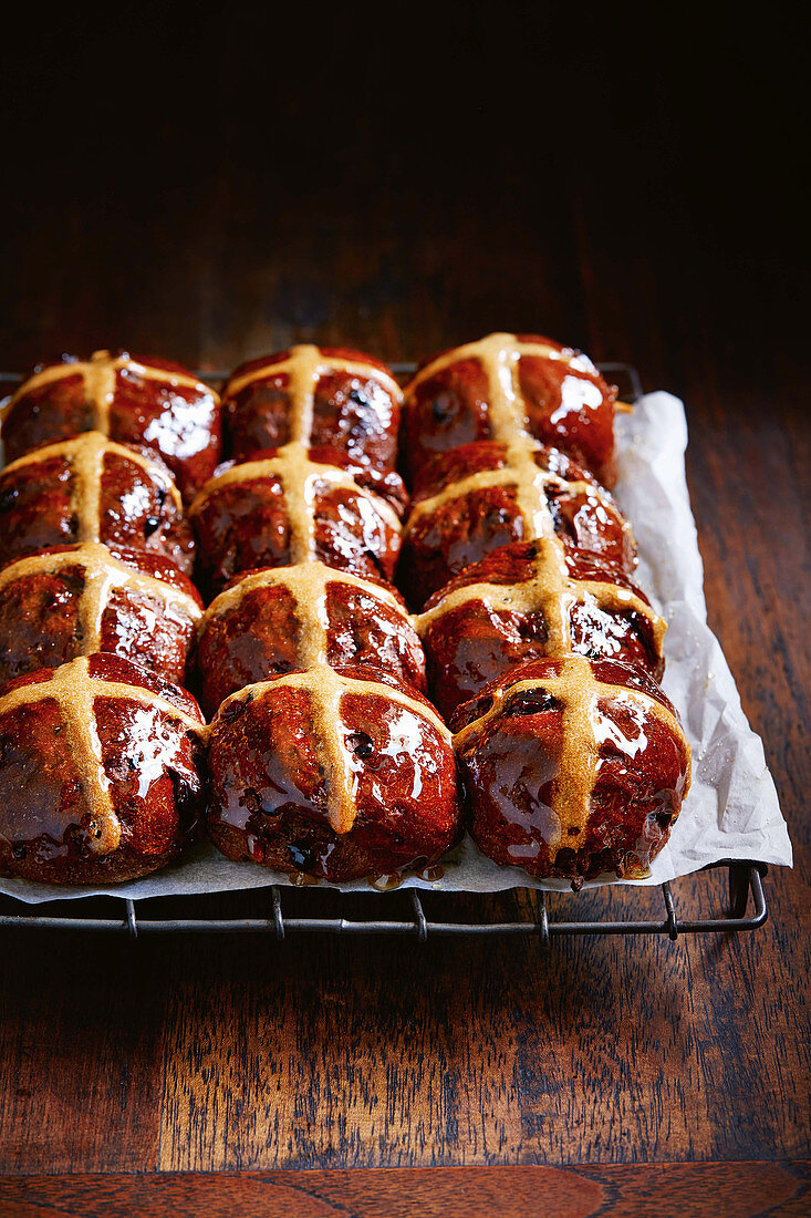 Chocolate hot cross buns with spelt on a cooling rack (vegan)