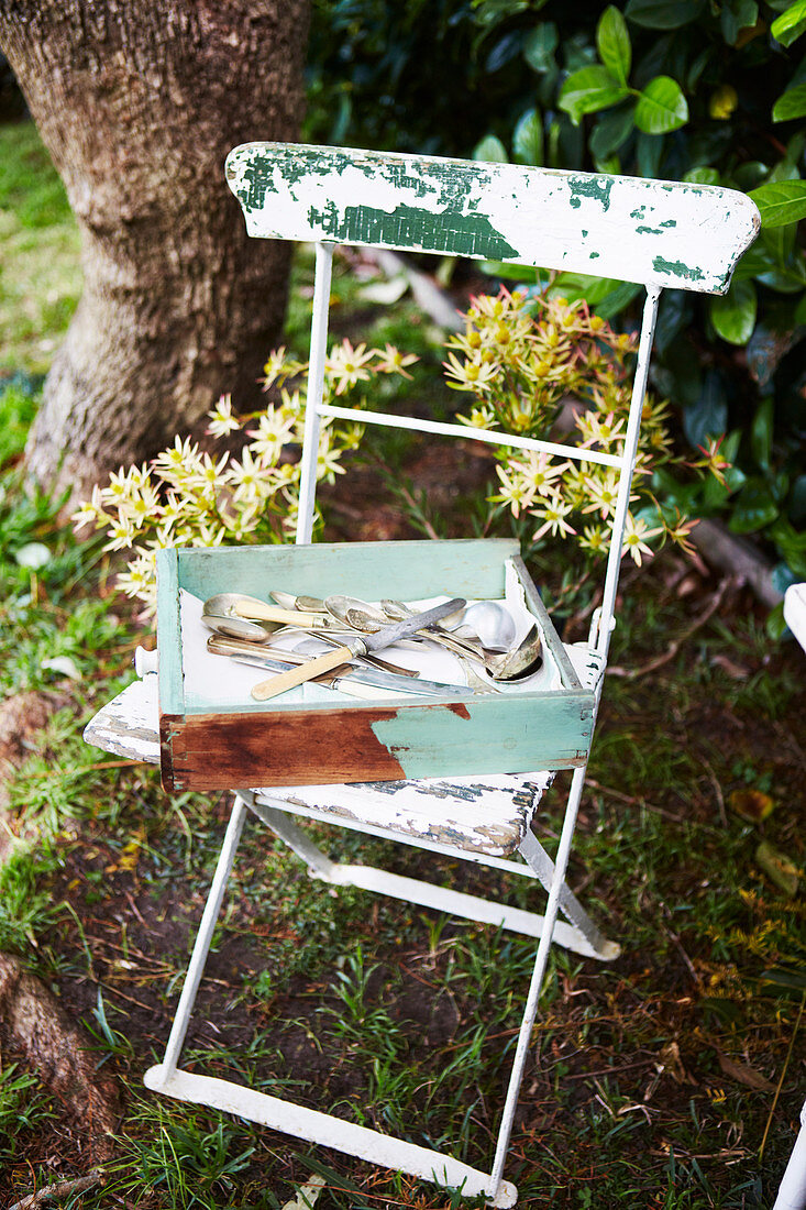 Besteckkasten auf Vintage Stuhl im Garten