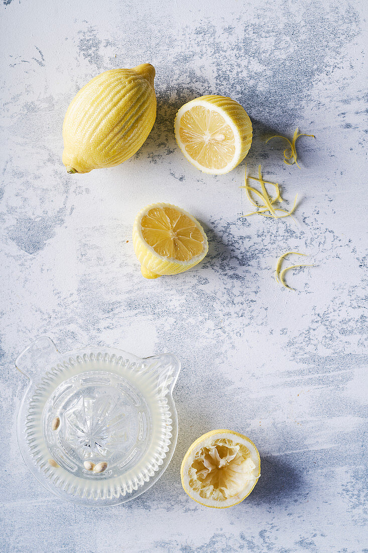 Peeled lemons and juicer, light background