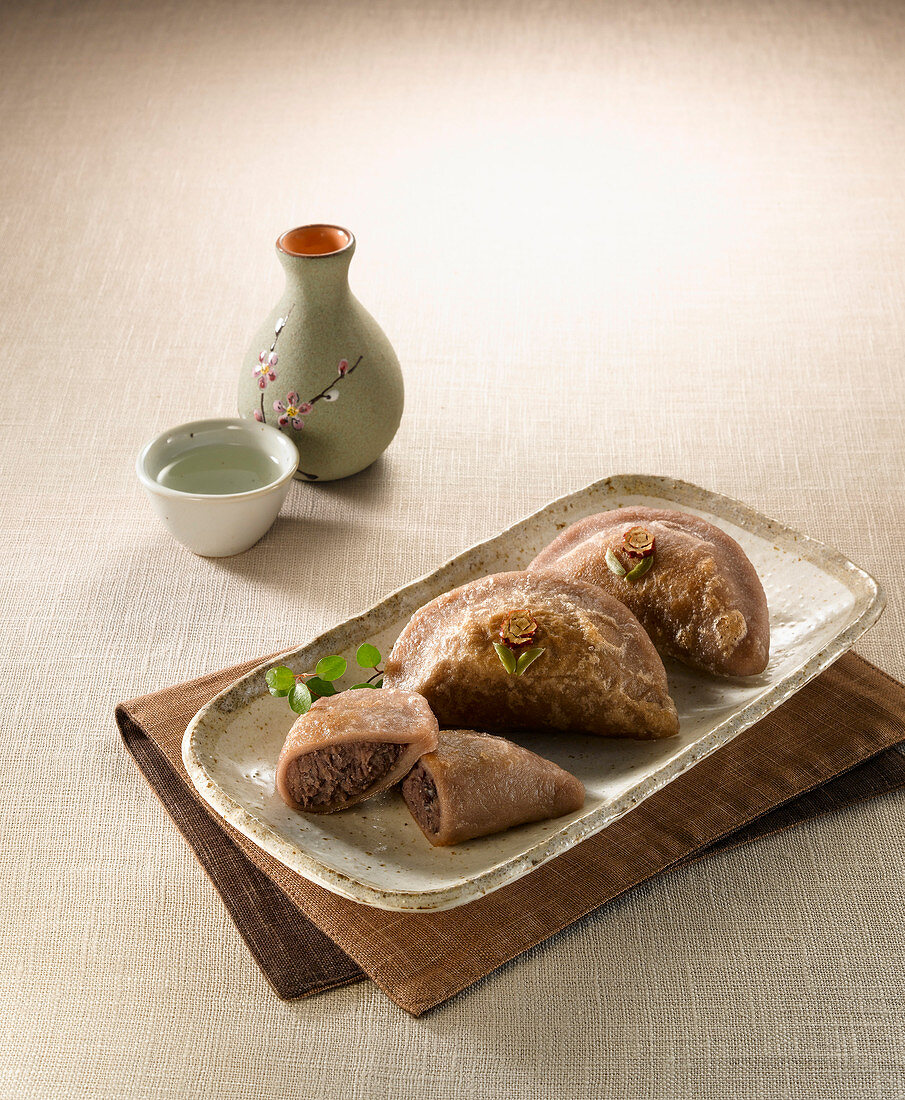 Asiatische Hirse-Teigtäschen serviert mit Sake (Japan)
