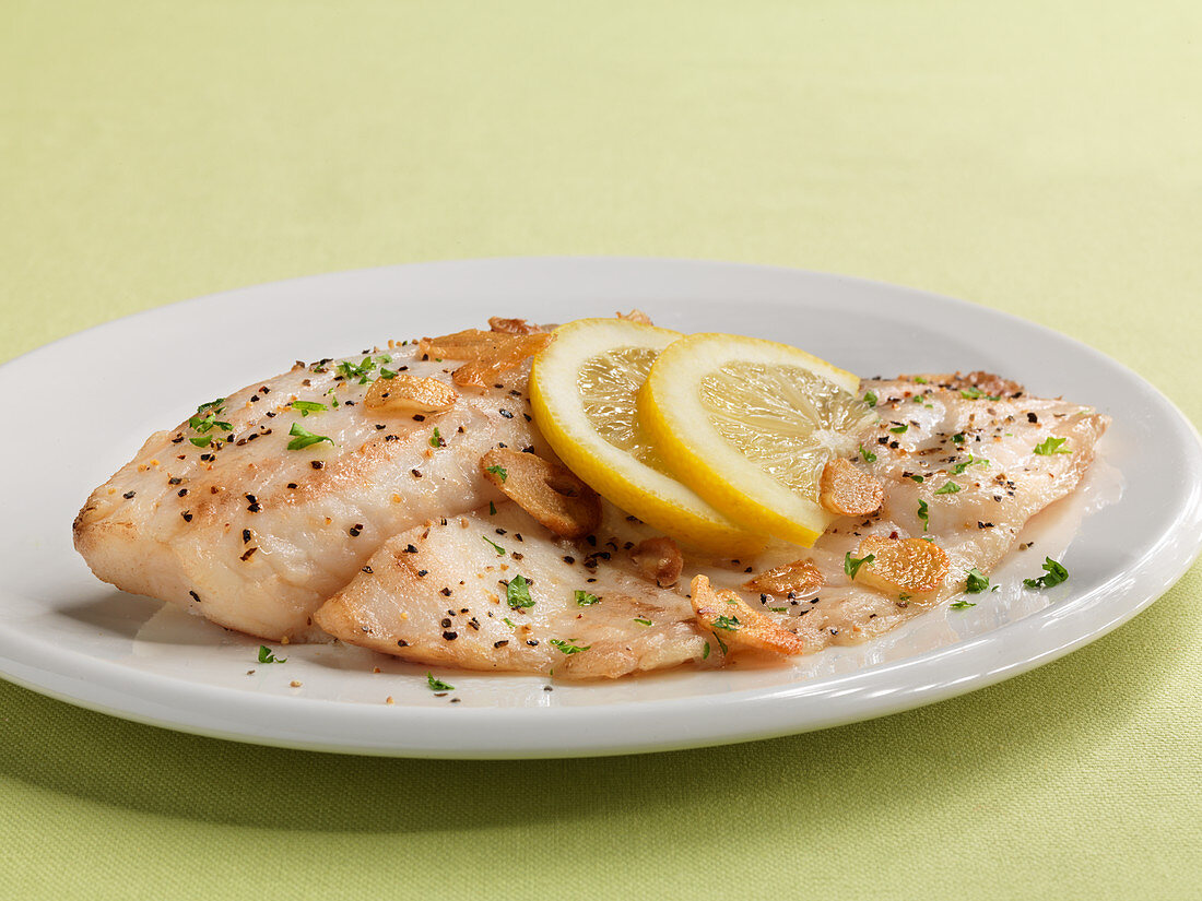 Tilapia fillets with garlic and lemon slices