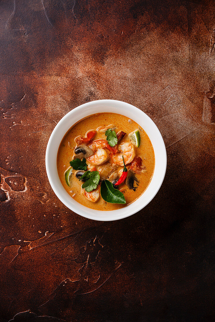 Tom Yam kung Spicy Thai soup with shrimp, seafood, coconut milk and chili pepper in bowl copy space