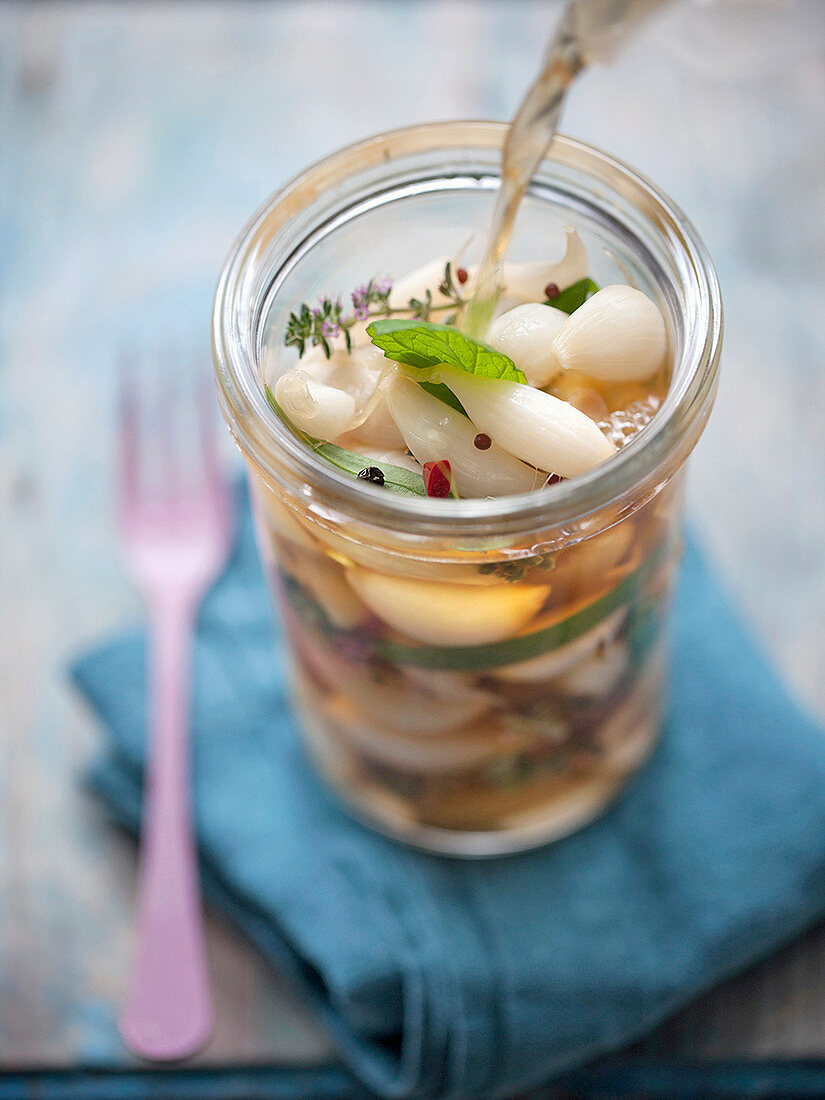 Eingelegten Knoblauch mit Kräutern und Chili zubereiten