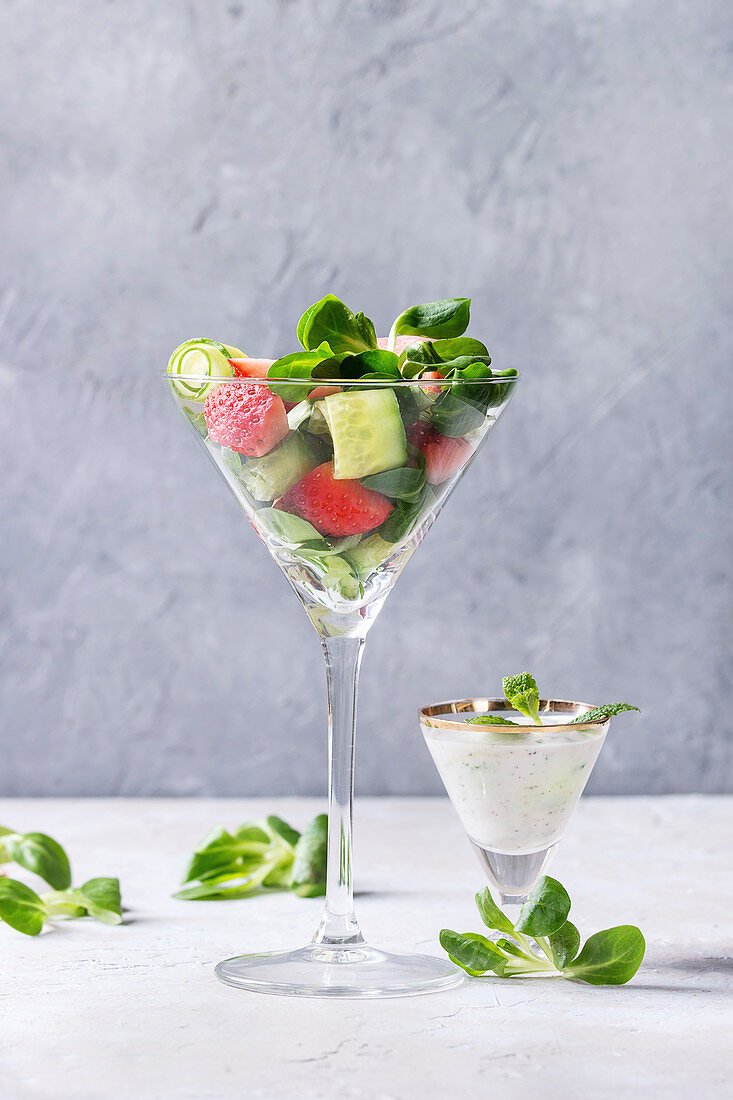 Spring summer diet salad with strawberries, cucumber, green field salad and yogurt mint sauce served in cocktail glass