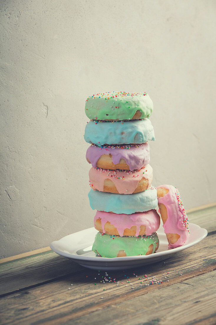 A stack of donuts on wooden table against the wall