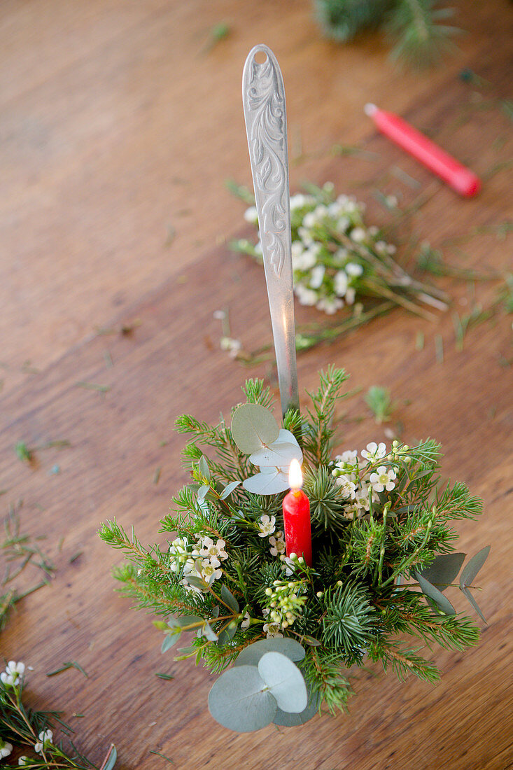 Weihnachtliches Gesteck mit Kerze in einem Schöpflöffel