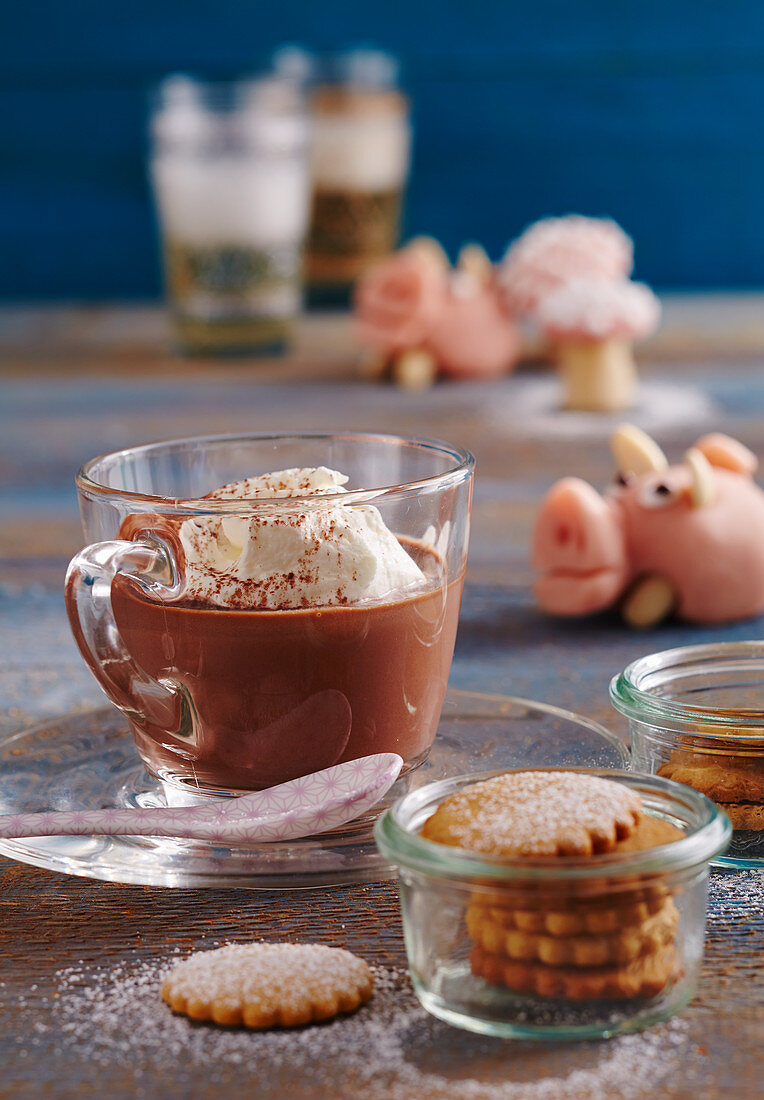 Hot Russian chocolate with vodka and cream, honey biscuits in a jar, and a marzipan pig