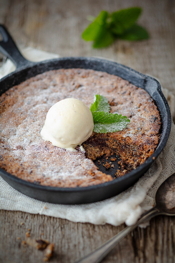 Chocolate chip cake with vanilla ice cream in a cast iron pan