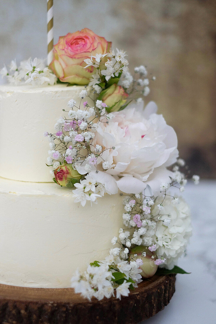 Zweistöckige Hochzeitstorte mit Buttercreme und frischen Blumen