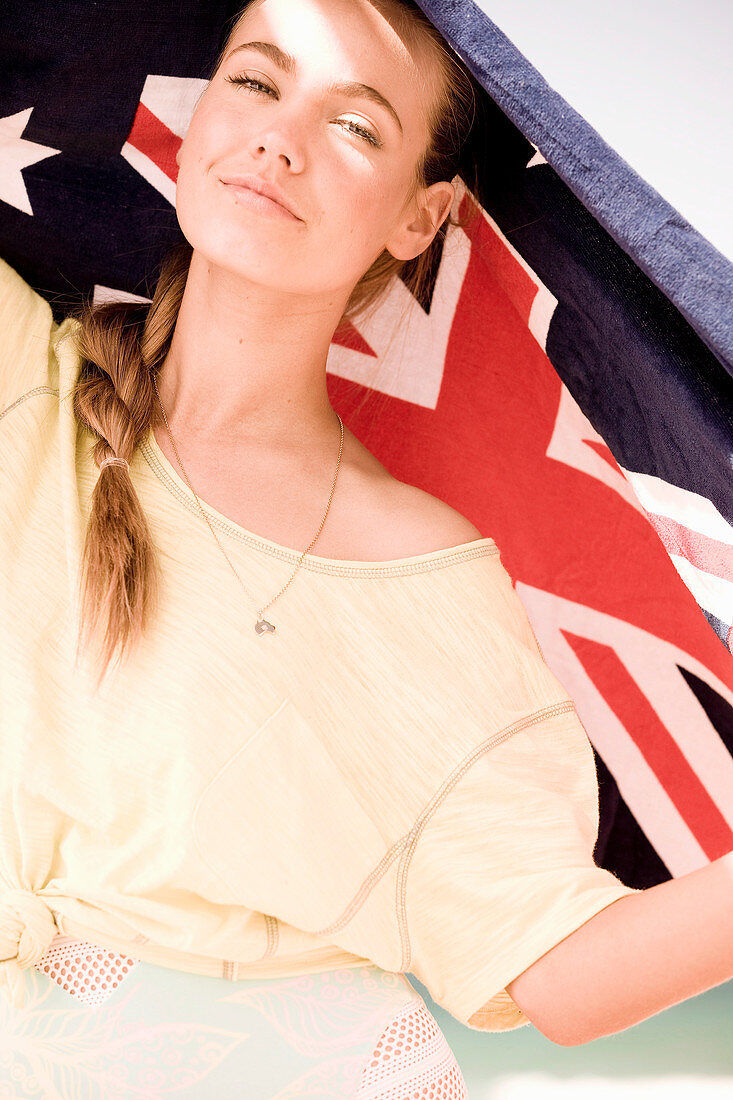 A young woman wearing a yellow top with an Australian beach towel