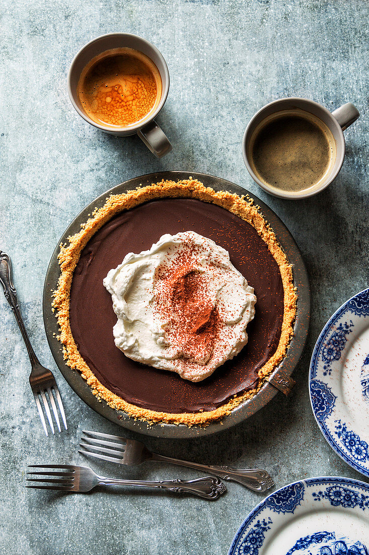 Chocolate pie with whipped cream on top and dusted with cocoa powder