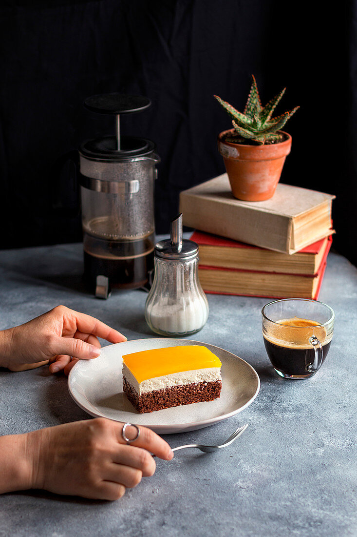 Young female serving a slice of chocolate and orange jelly cake