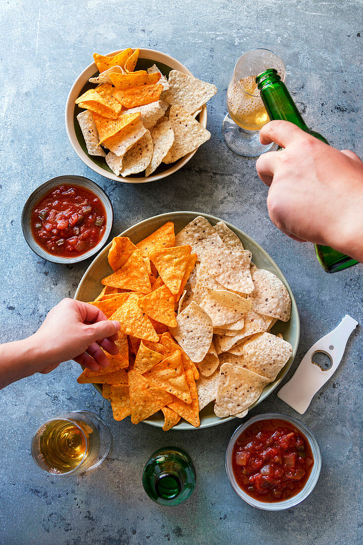 Zweierlei Tortilla-Chips serviert mit Salsa und Bier (Mexiko)