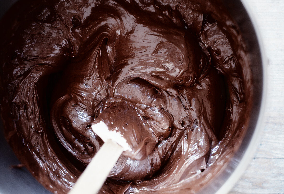 Melted chocolate glaze being stirred