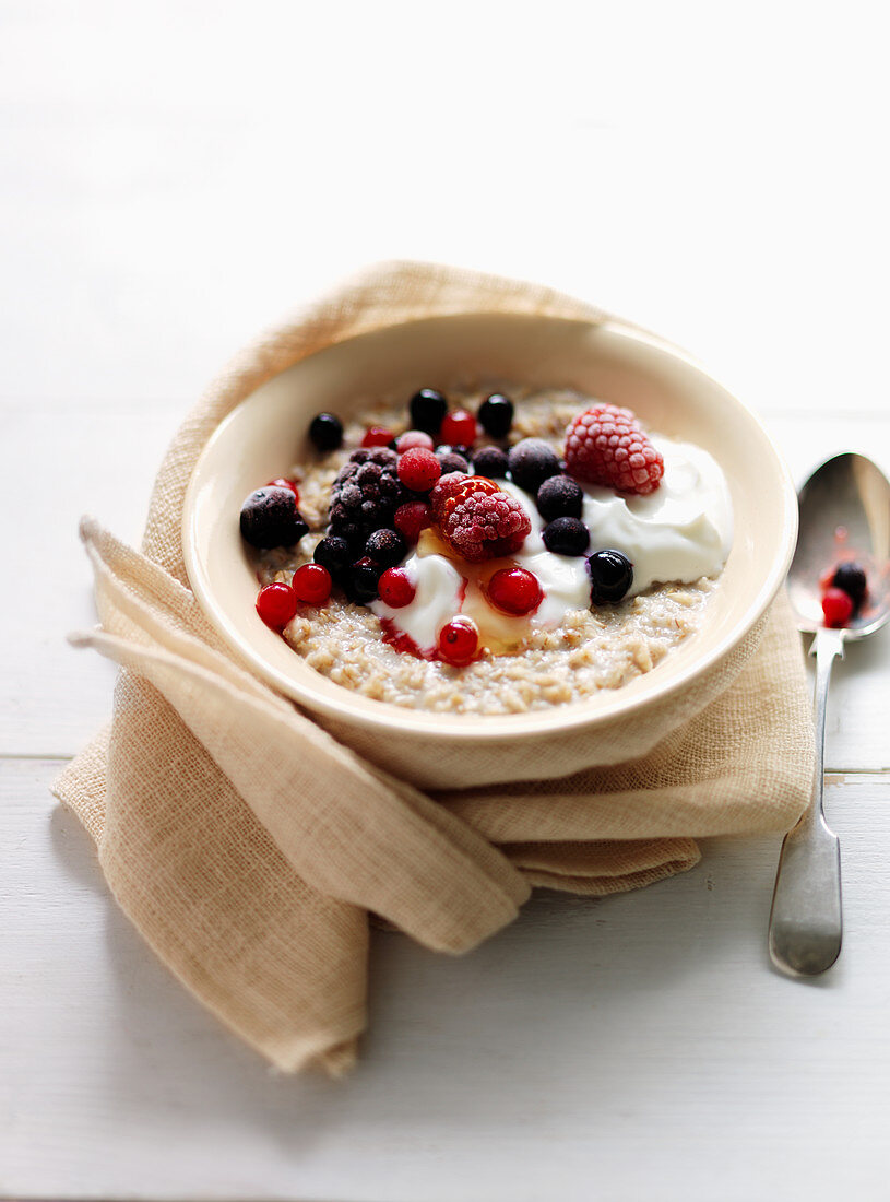 Porridge with mixed berries, cream and honey