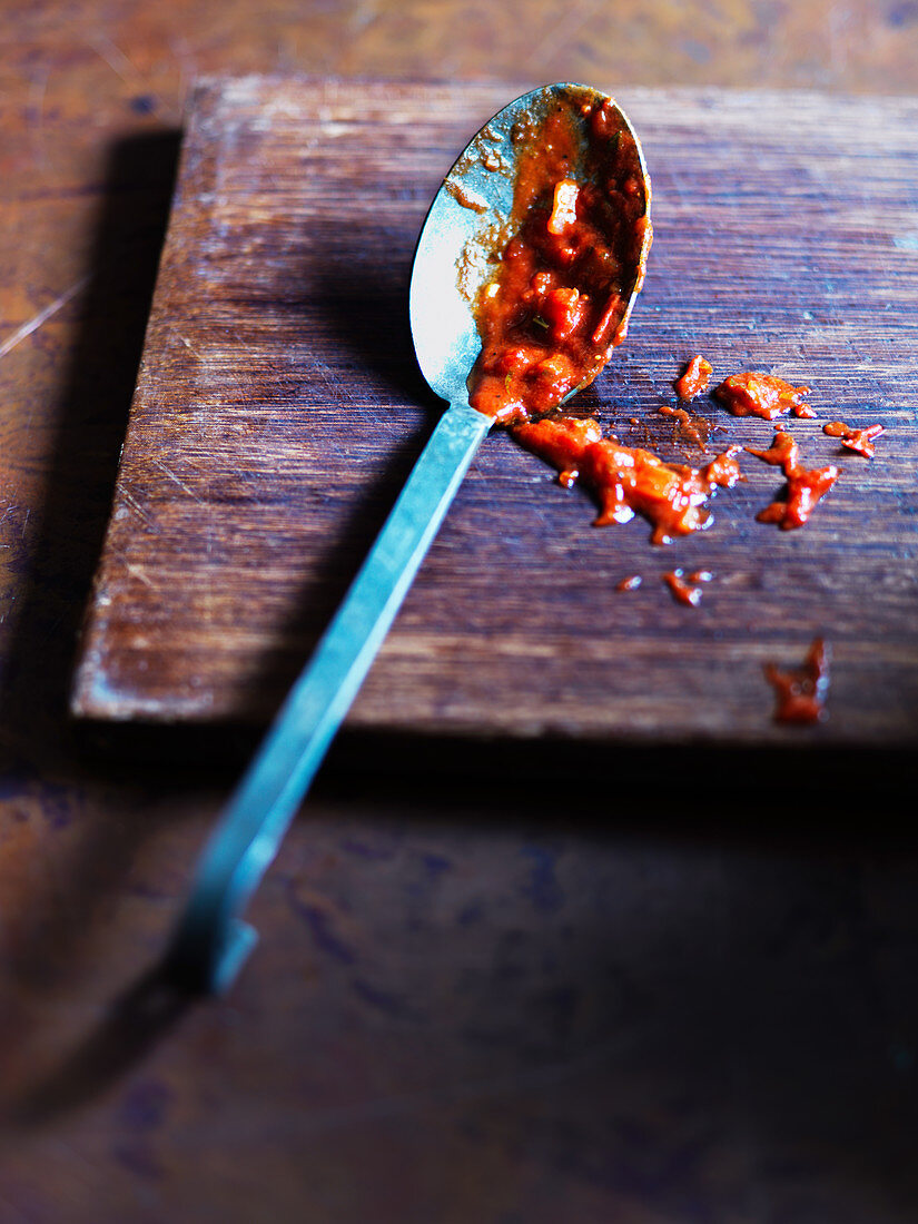 A spoon with tomato sauce