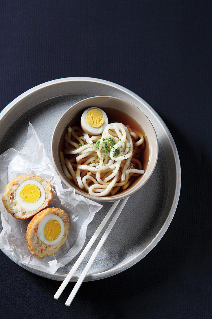 Japanische Udonnudeln und Fischkrokett mit gekochtem Ei gefültt