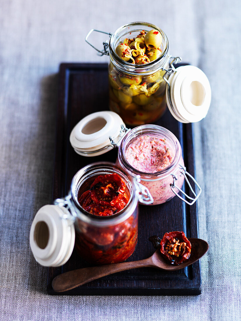 Tomatoes, hummus and preserved olives in flip-top jars