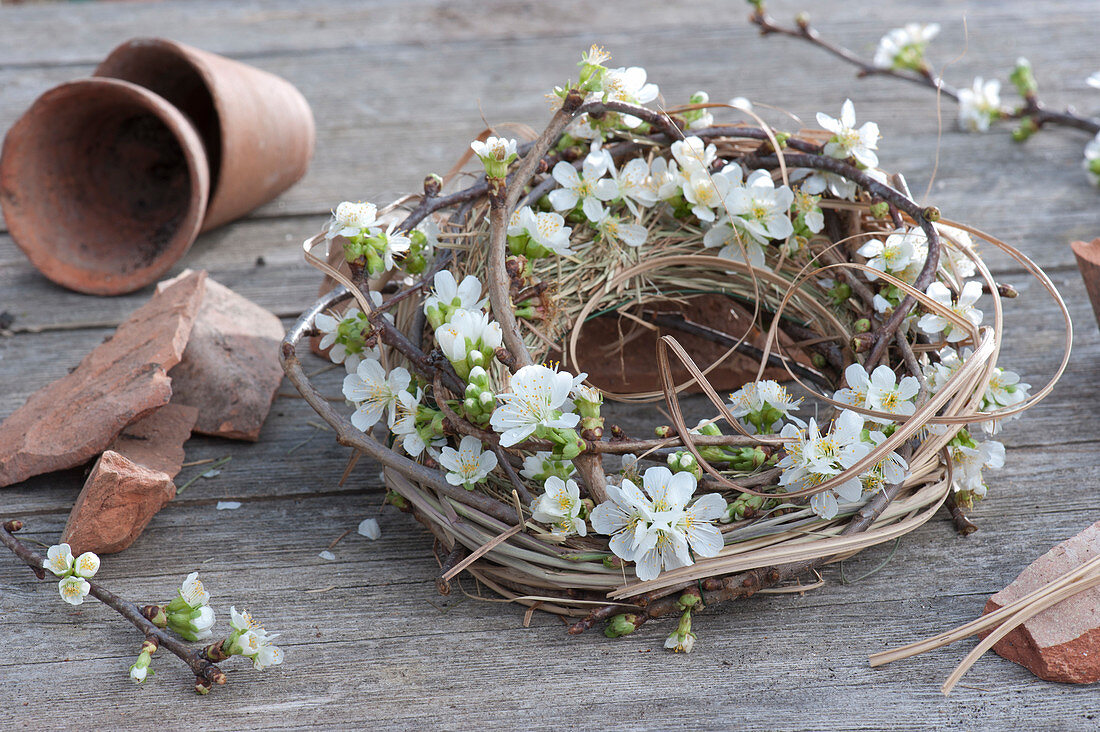 Kranz aus Gras und Zweigen mit Kirschblüten