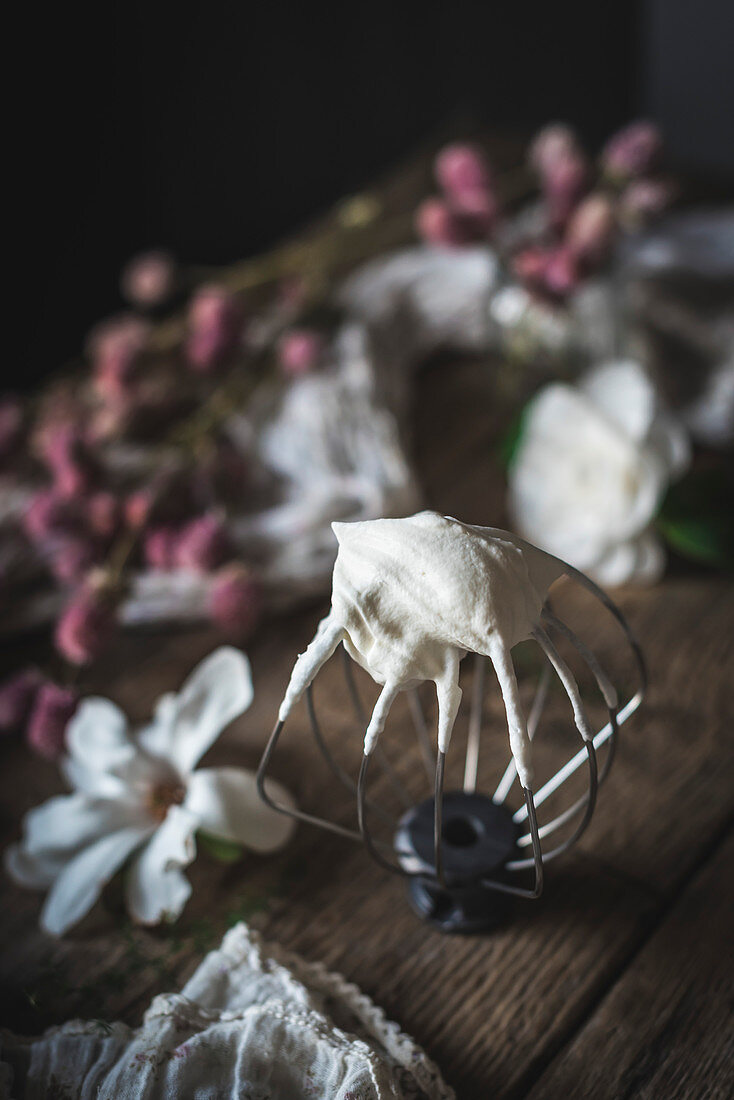 A whisk covered in whipped cream