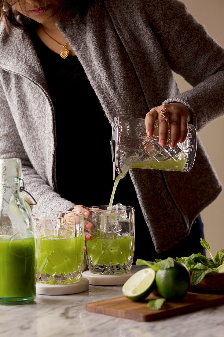 Woman making a Cucumber Lime Cocktail
