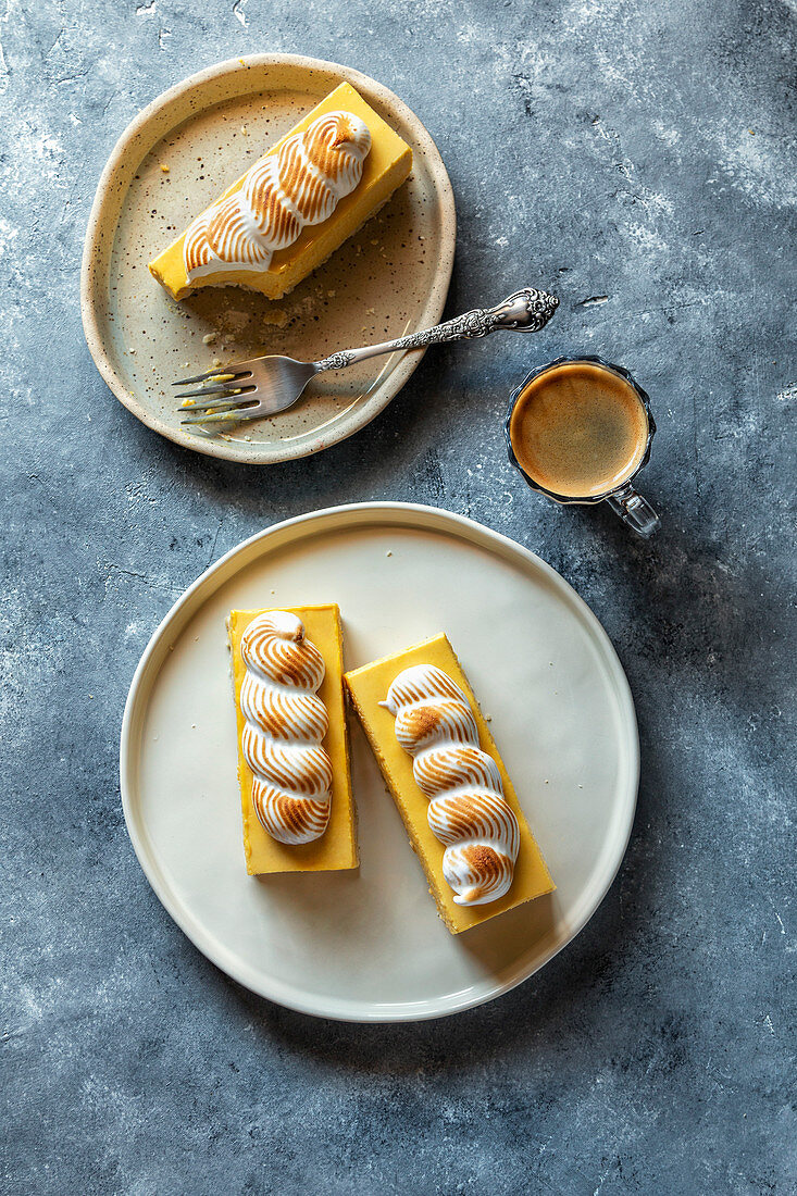 No bake lemon bars with toasted meringue on top an a cup of coffee on the table