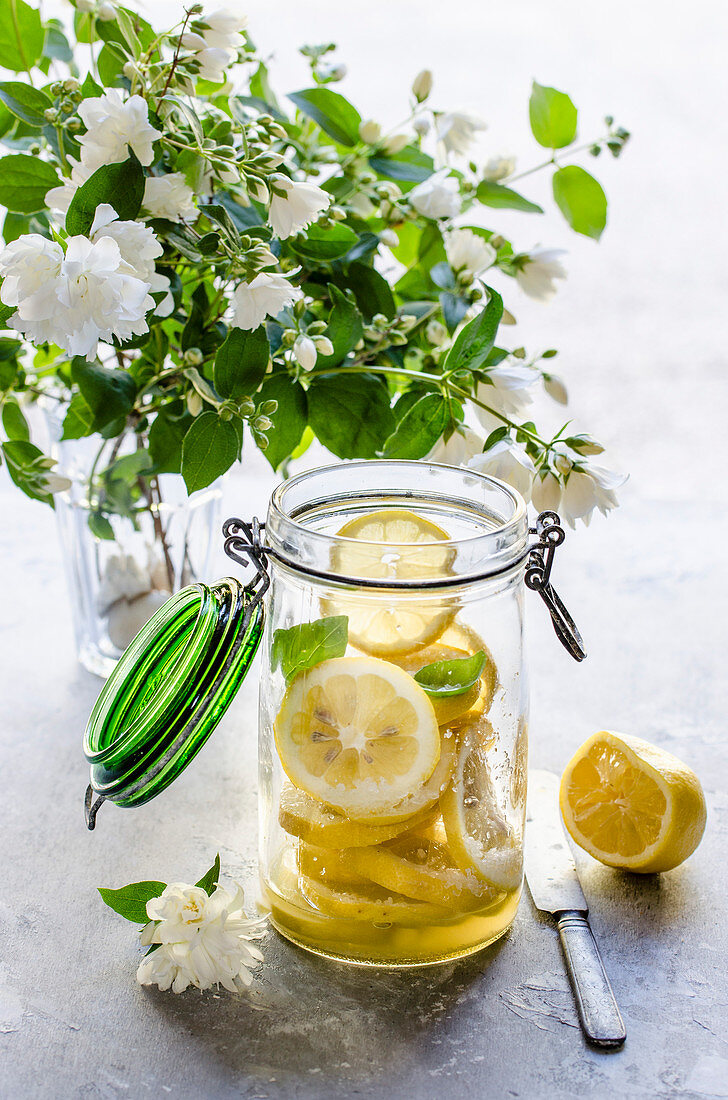 Making preserved lemon, sliced fresh lemons in a jar
