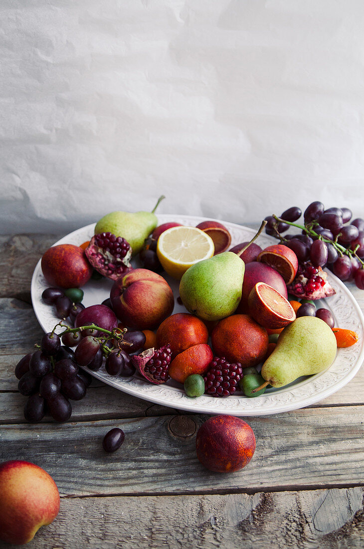 Obstteller mit Granatapfel, Trauben, Birnen und Nektarinen