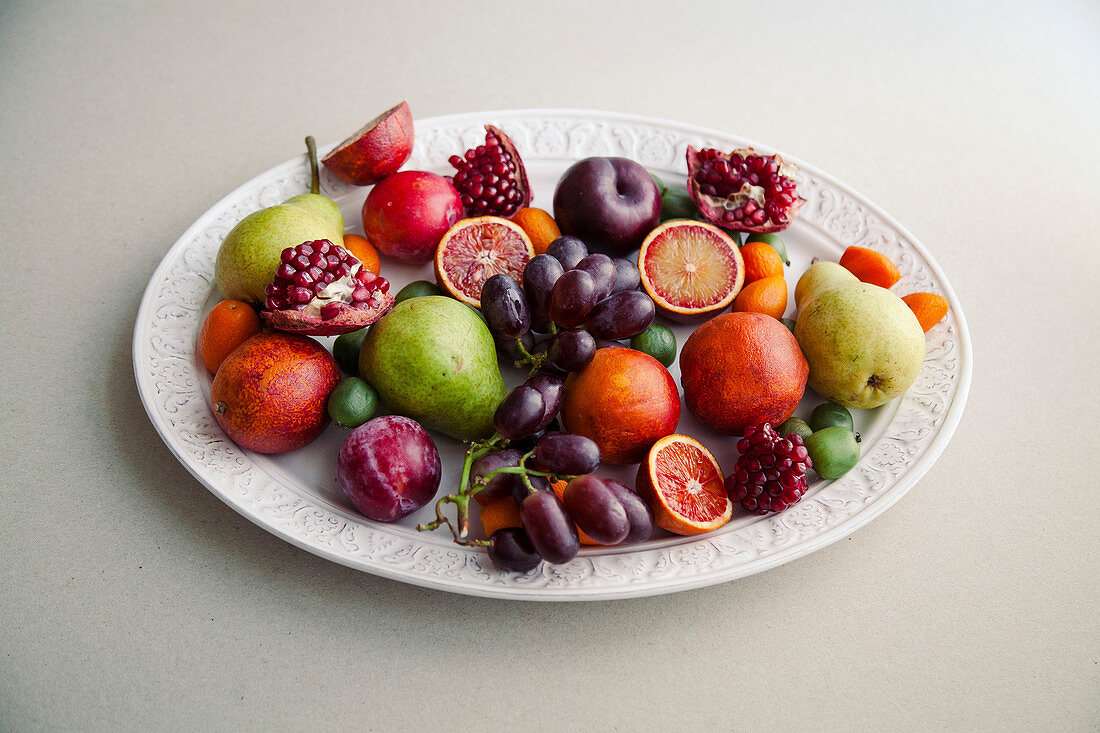 Obstteller mit Mini-Kiwis, Granatapfel, Trauben, Birnen, Pflaumen und Nektarinen
